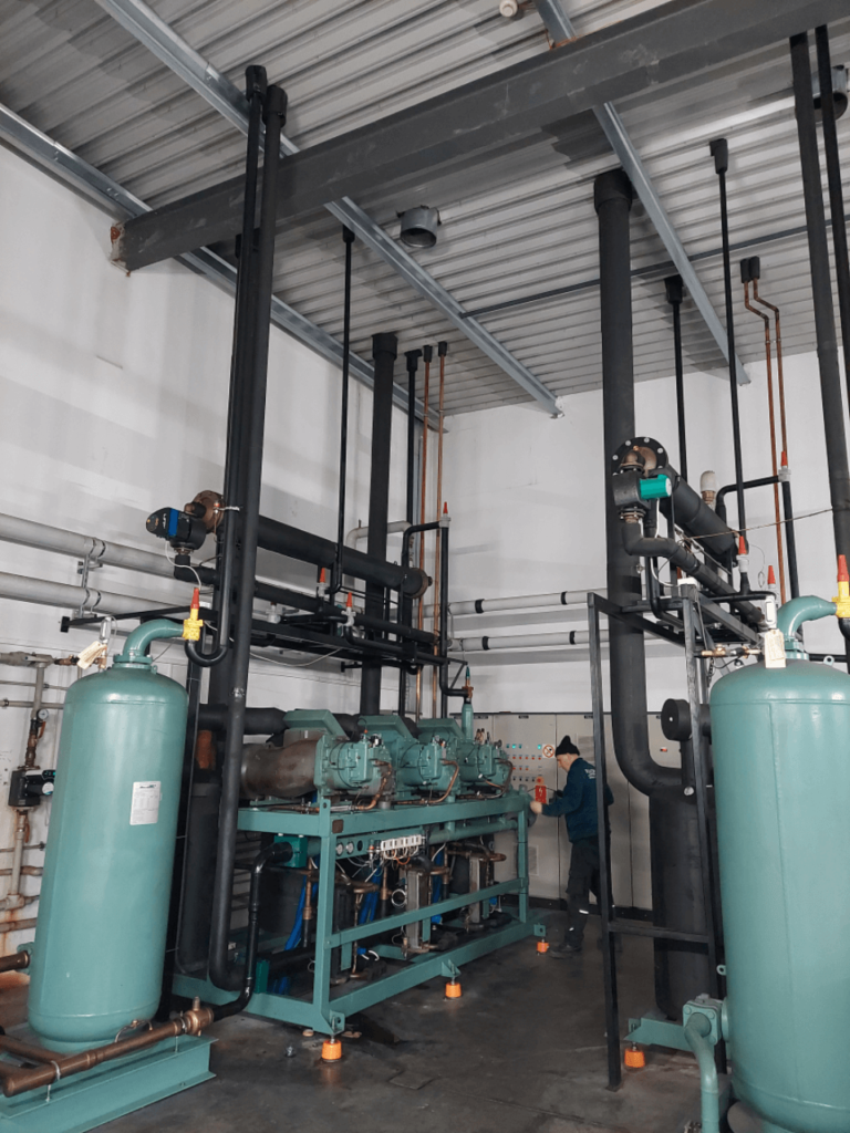 Kontrola parametrów systemu chłodniczego – technik sprawdzający szafę sterowniczą w maszynowni.